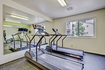 a gym with cardio equipment and weights in a building with green walls at Gateway, Chico, CA 95926